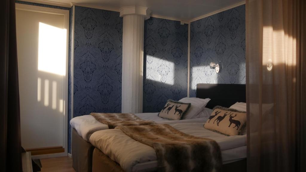a bedroom with a bed with a fur blanket on it at Hotel Golden Circle Suites in Rovaniemi