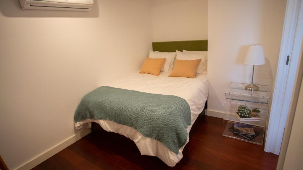 um quarto com uma cama com almofadas laranja e verde em dourobluehouse em Marco de Canavezes