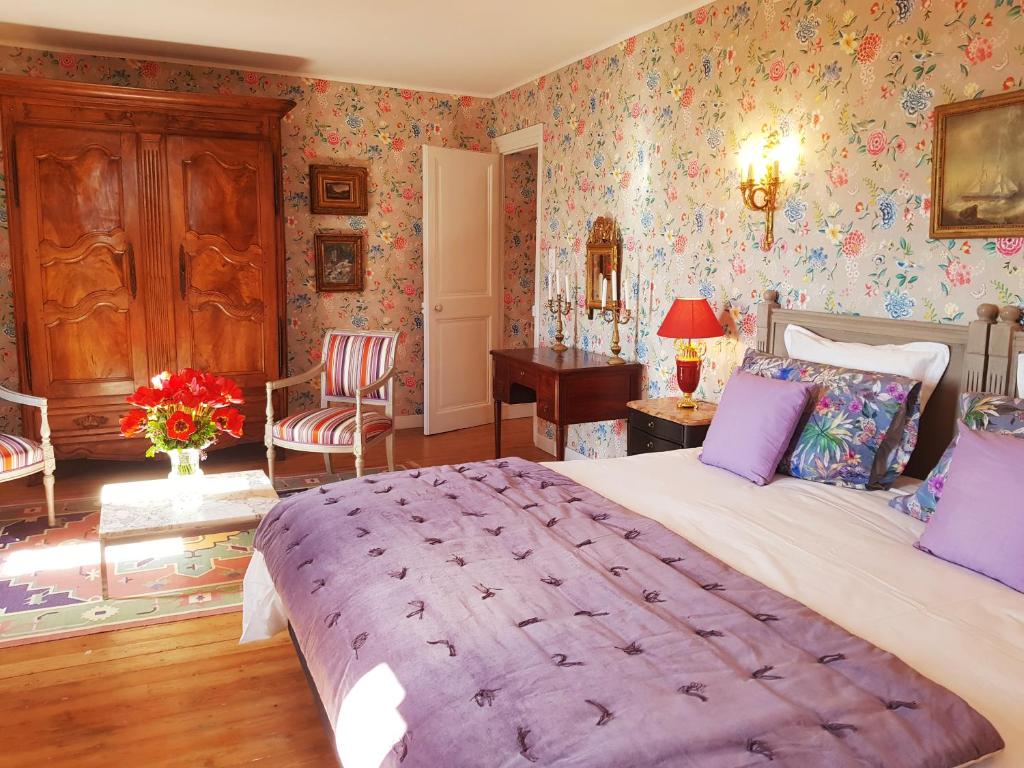 a bedroom with a large bed and floral wallpaper at Chateau de Hiéville in Hiéville