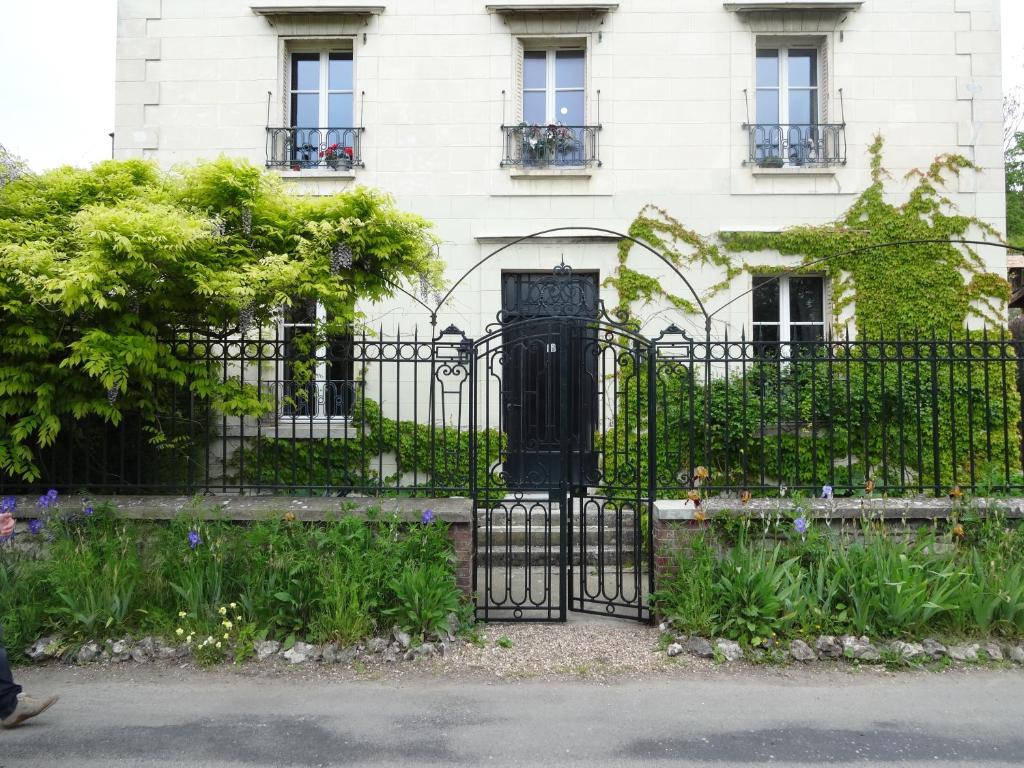 una puerta negra frente a un edificio blanco en Le Clos de l'Eglise - Inès, en Giverny