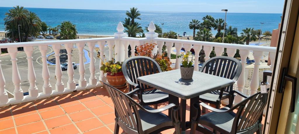 a table and chairs on a balcony with the ocean at Apartamentos Bellavista in Puerto de Mazarrón