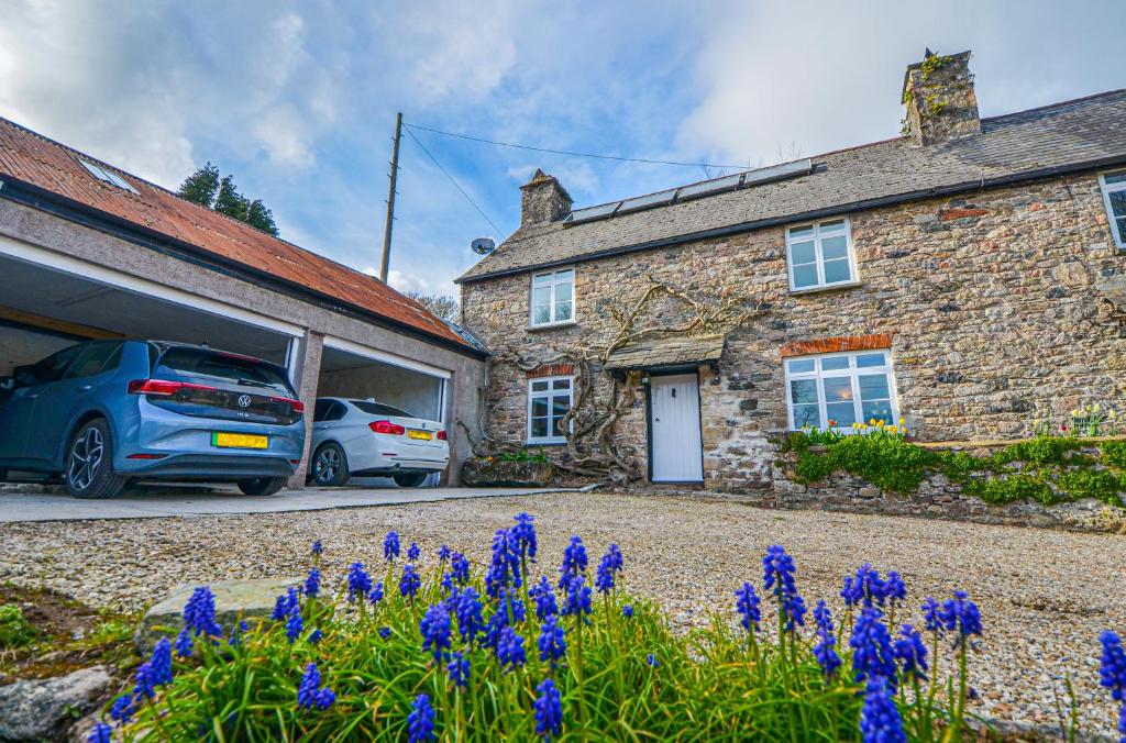 two cars parked in front of a building with purple flowers at The Annex at Middle Filham, Ivybridge in Ivybridge