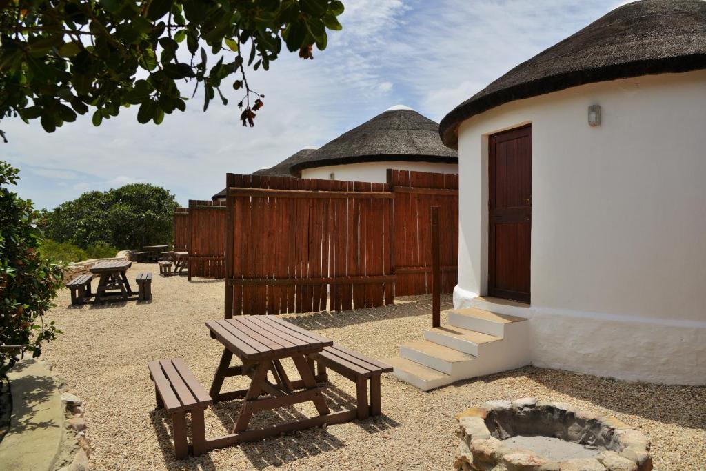 a patio with benches and a building with a fence at De Hoop Collection - Campsite Rondawels in De Hoop Nature Reserve