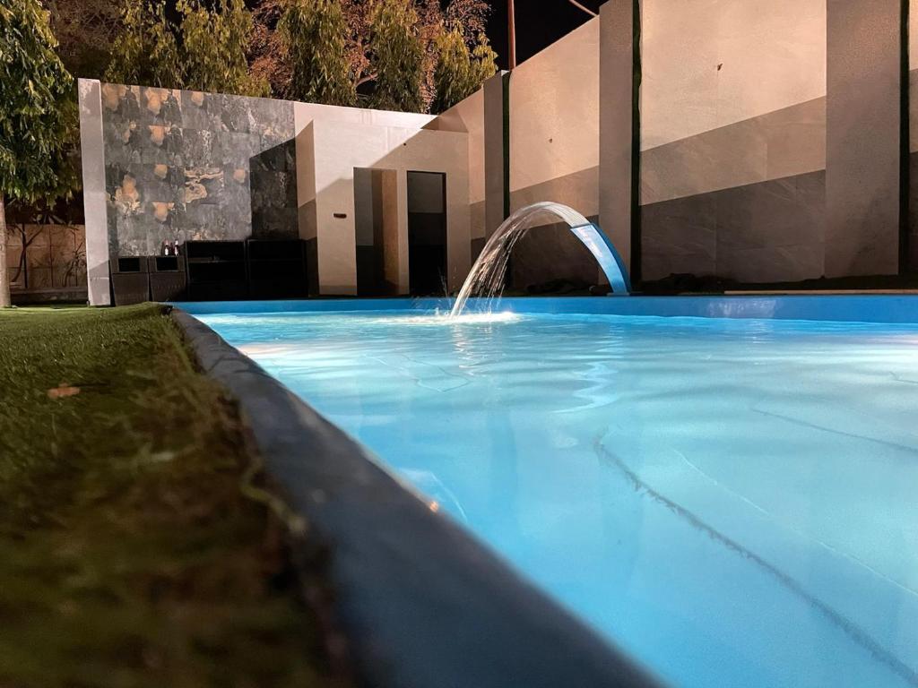 una piscina azul con una fuente de agua en Holy River Hotel, en Rishīkesh