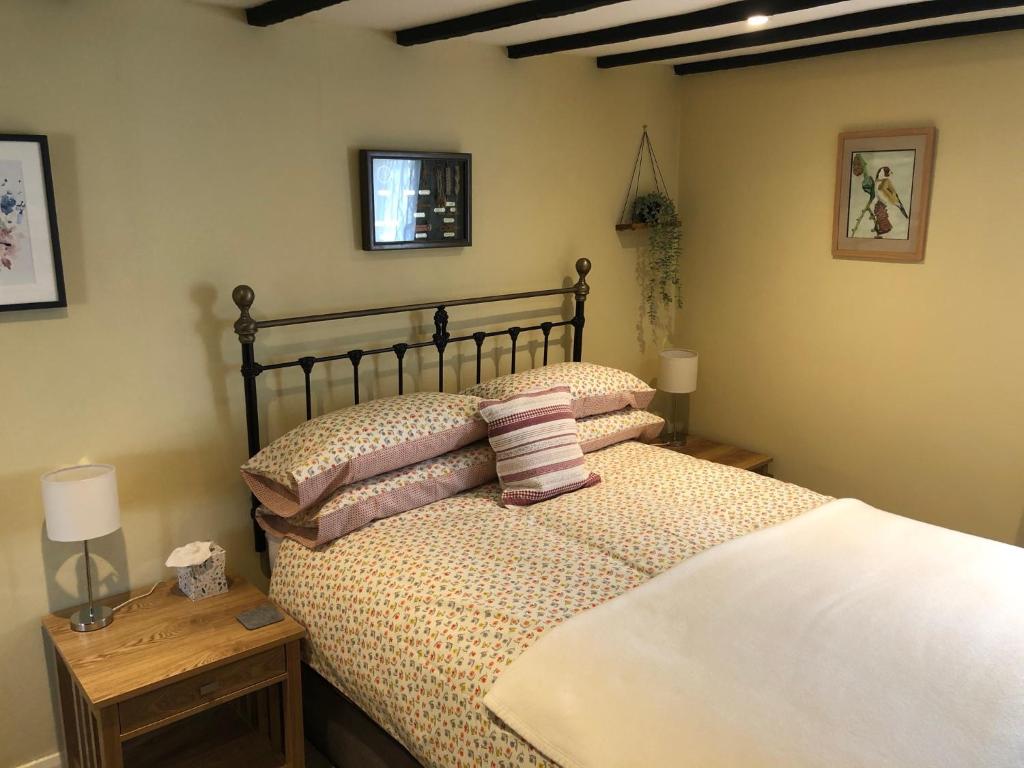 ein Schlafzimmer mit einem Bett mit Kissen darauf in der Unterkunft Oriel Cottage in Pevensey