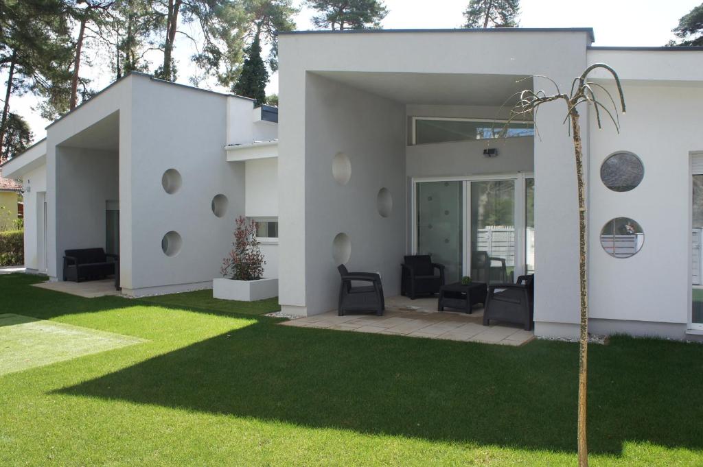 a white house with a yard with green grass at Bori Villa Siófok in Siófok