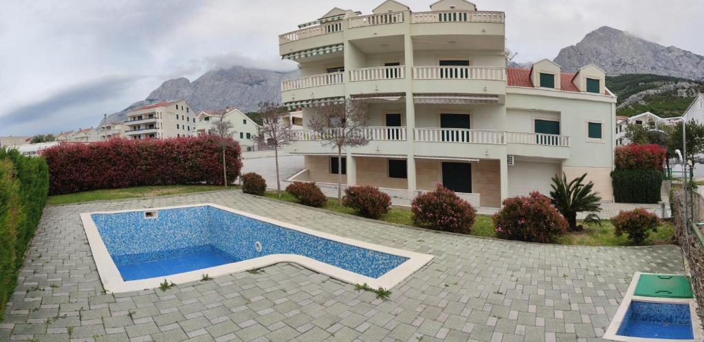 - un grand bâtiment avec une piscine en face dans l'établissement Apartment Veronika, à Promajna