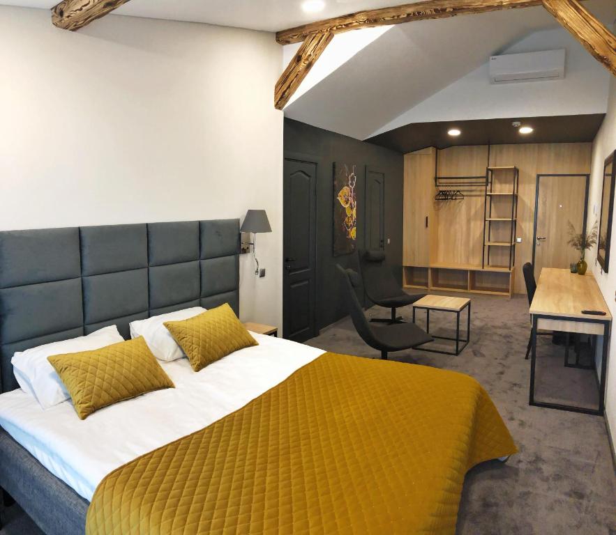 1 dormitorio con 1 cama grande con manta amarilla en Senoji užeiga en Molėtai