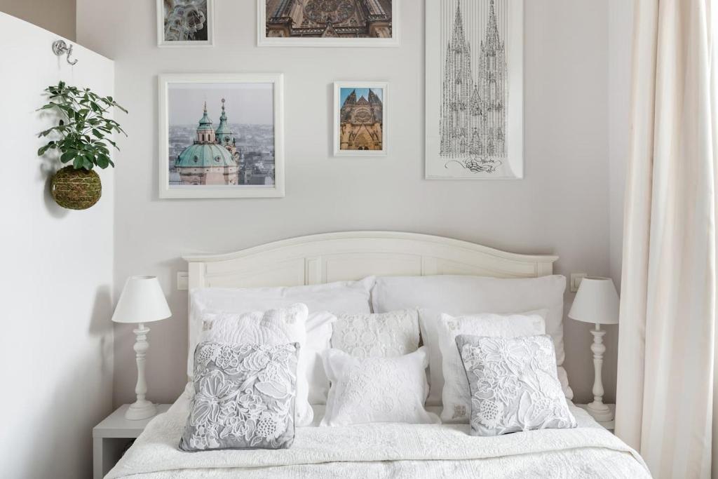 um quarto branco com uma cama branca com almofadas em Old Town Square Apartment em Praga