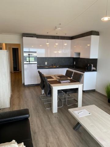 a kitchen with a table and chairs in a room at Studio 405 op zeedijk met frontaal zeezicht 4de verdiep in Middelkerke