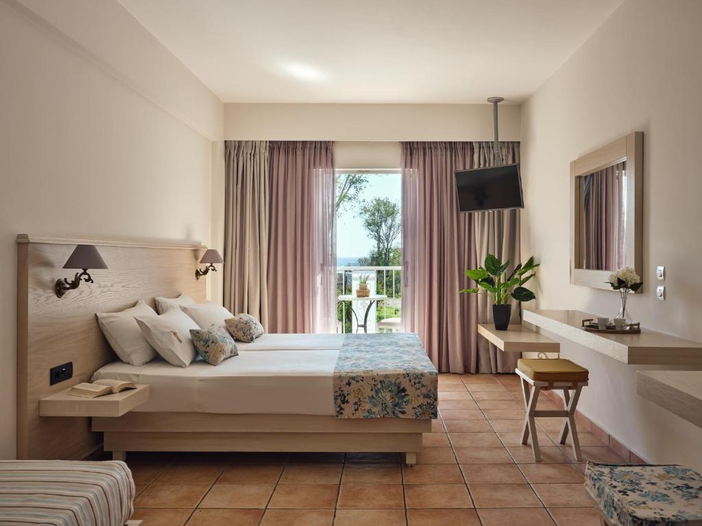 een hotelkamer met een bed en een raam bij Nemesis Aparthotel in Laganas