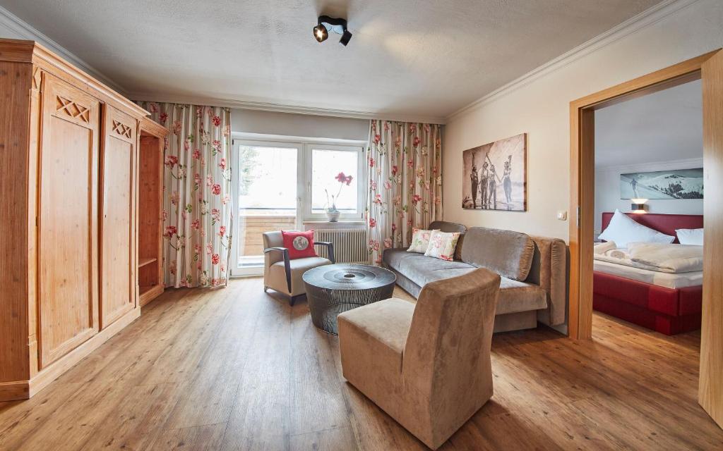 a living room with a couch and a bed at Hüttl Relax Appartements in Saalbach Hinterglemm