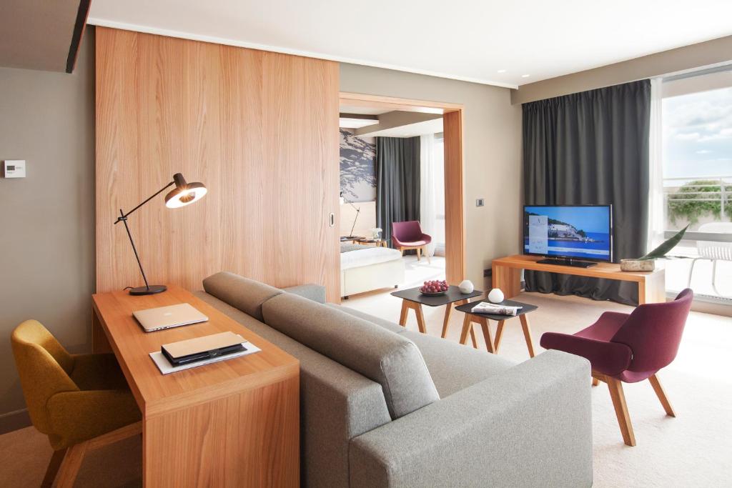 a living room with a couch and a television at Hotel Dubrovnik Palace in Dubrovnik