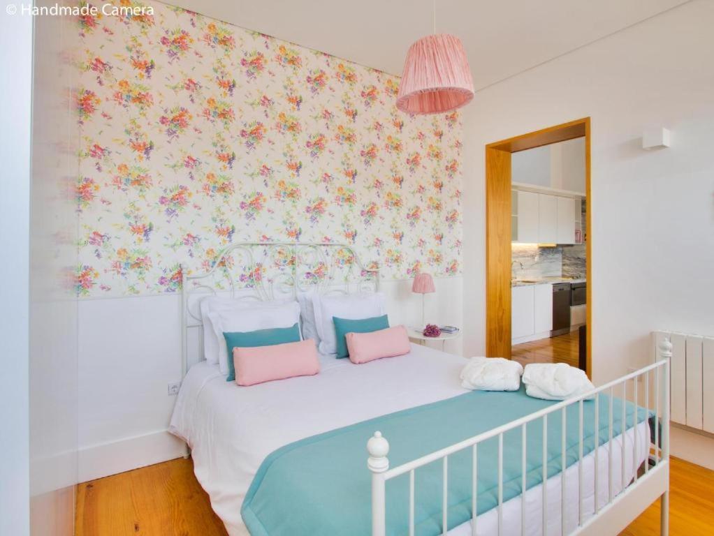 Inside Porto Apartments - Flores في بورتو: غرفة نوم مع سرير أبيض مع وسائد وردية وأزرق