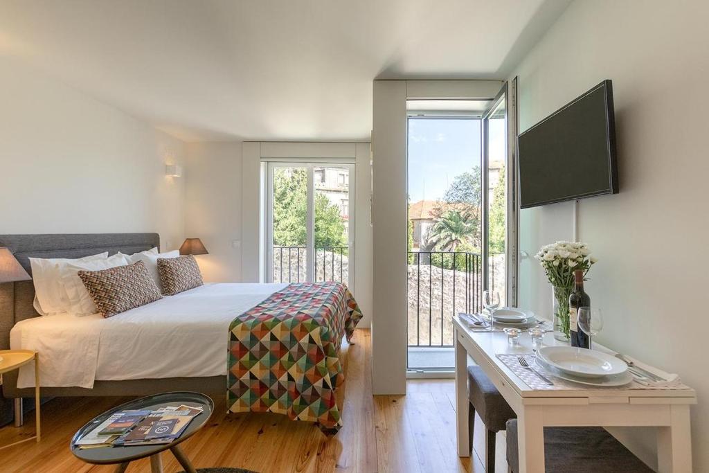 una habitación de hotel con una cama y un balcón en Inside Porto Apartments - Pinheiro, en Oporto