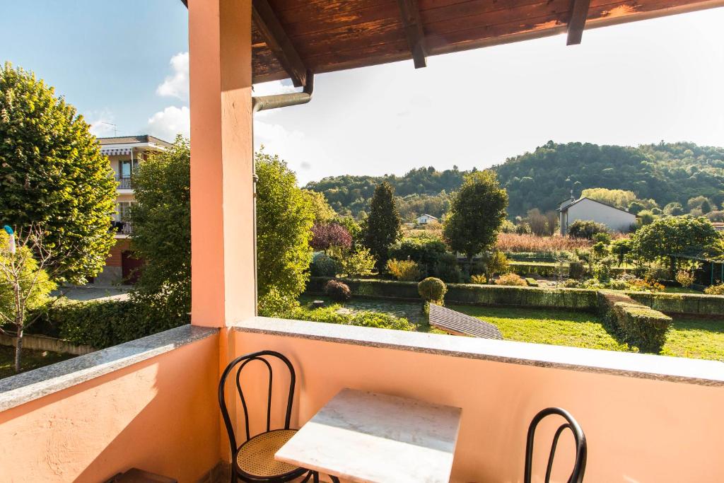 een balkon met een tafel en stoelen en uitzicht op een tuin bij Casa Angeletti in Gassino Torinese