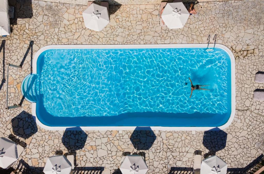 an overhead view of a person in a swimming pool at Aurora Beach Hotel in Agios Ioannis Peristerion