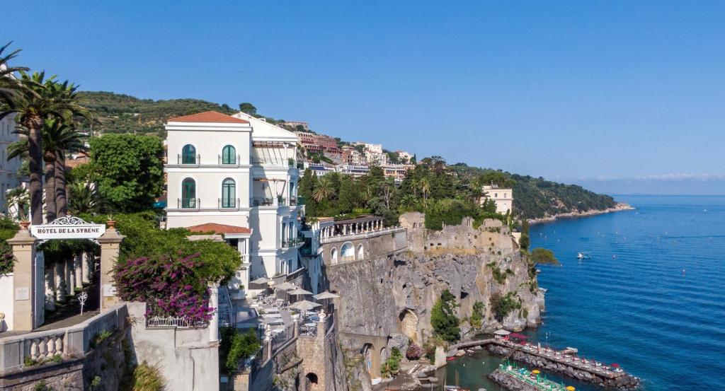 un gruppo di edifici su una scogliera vicino all'acqua di Bellevue Syrene a Sorrento