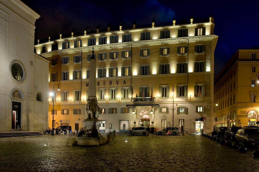 a large building with a clock on the front of it at Grand Hotel De La Minerve in Rome