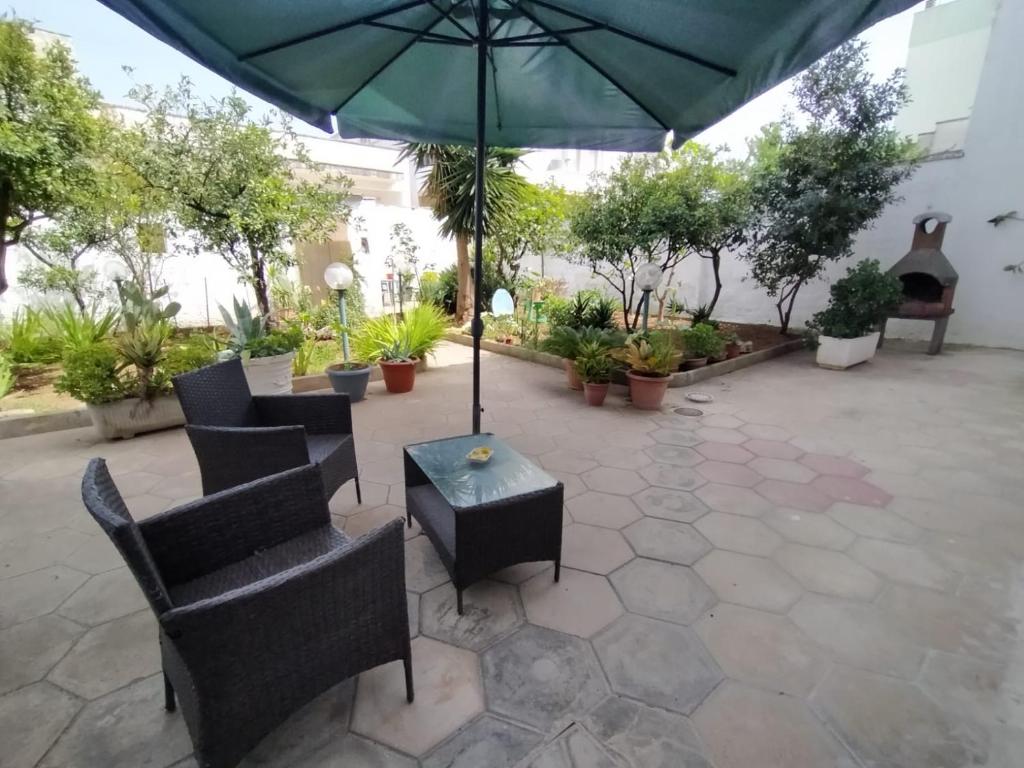 a patio with chairs and a table with an umbrella at A casa di Raffaella e Antonio in Surbo