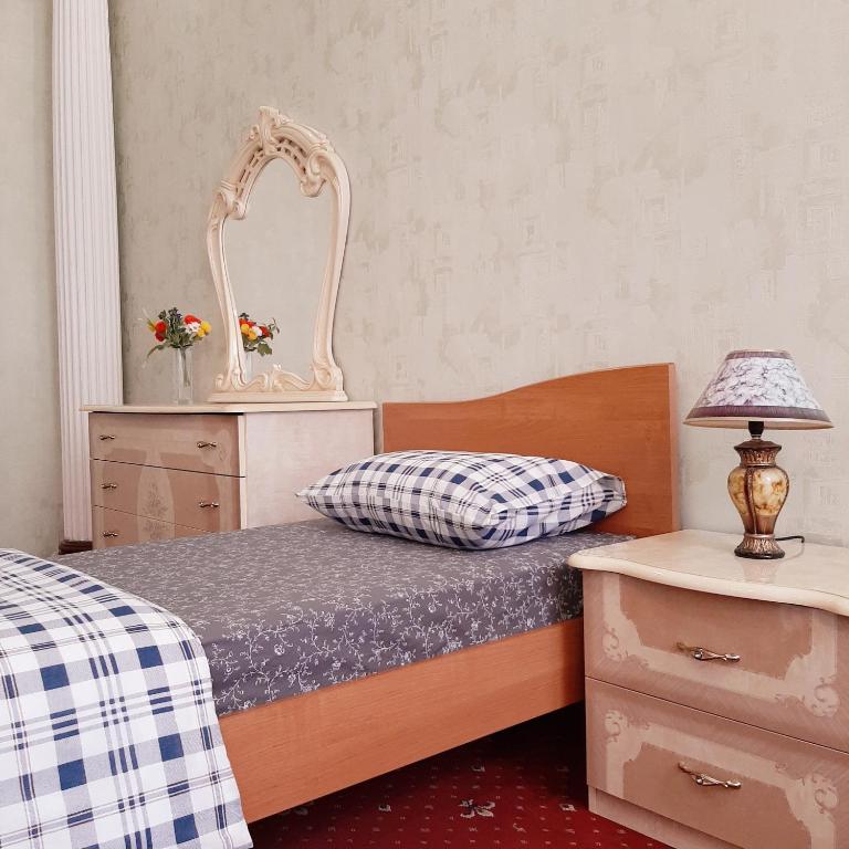 een slaapkamer met een bed met een spiegel en een dressoir bij Хостел Арбат 29 in Moskou