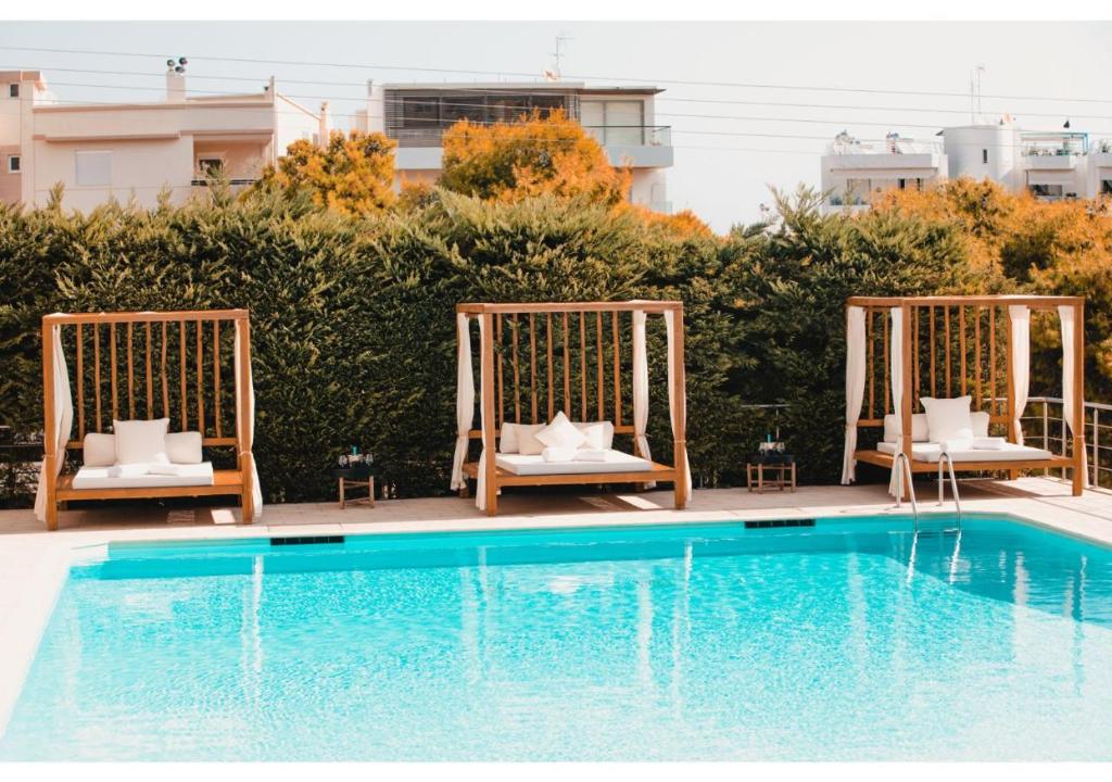 a swimming pool with two chairs and a swing at Blue Note Resort & Club in Athens