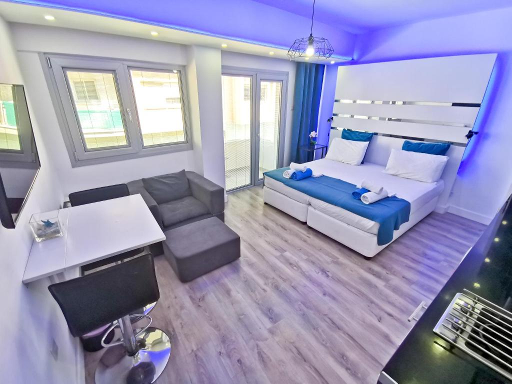 a bedroom with a bed and a couch and a table at Mariandry Apartments in Larnaca