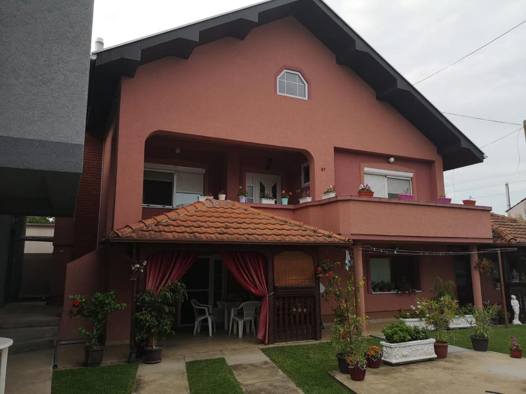 Casa roja con balcón y patio en Apartmani Stanikić en Kostol