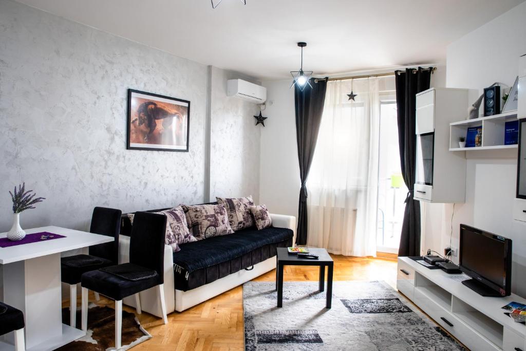 un soggiorno con divano e tavolo di Apartman Black Star a Novi Sad