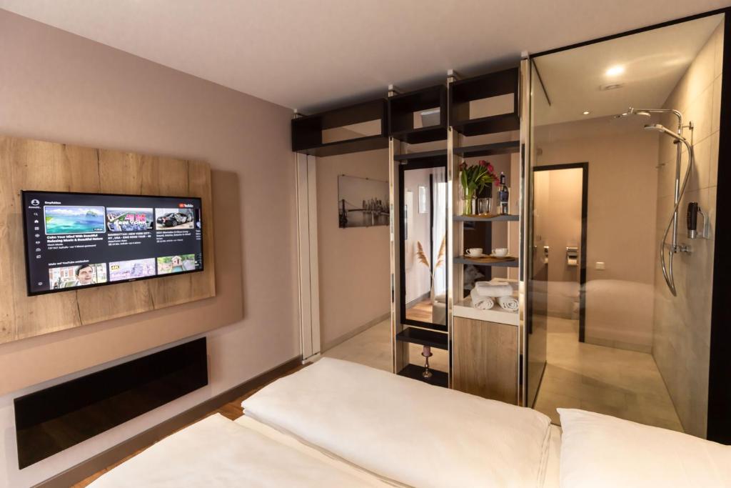 sypialnia z łóżkiem i telewizorem na ścianie w obiekcie 24Seven Hotel Schwabach w mieście Schwabach