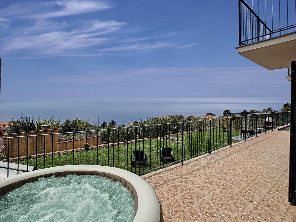 a hot tub on a patio with a fence at Casa da Felicidade by LovelyStay in Prazeres