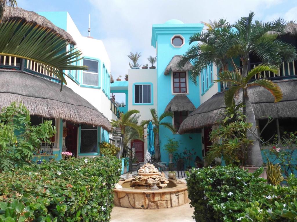 a blue building with a fountain in front of it at Casa Gatos in Akumal
