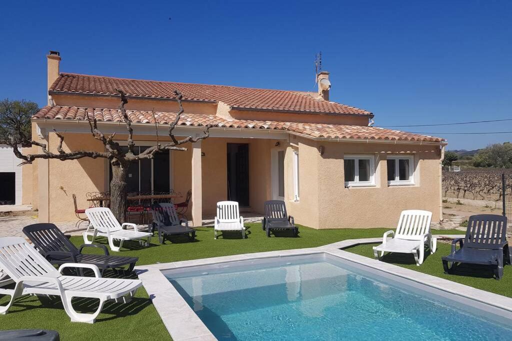 a villa with a pool and chairs and a house at Casevielle le haut in Tulette