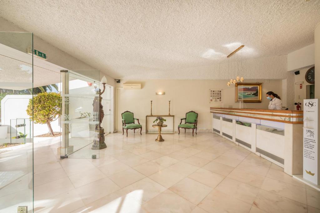 a large room with a counter and chairs in it at Carvoeiro Garden Hotel in Carvoeiro