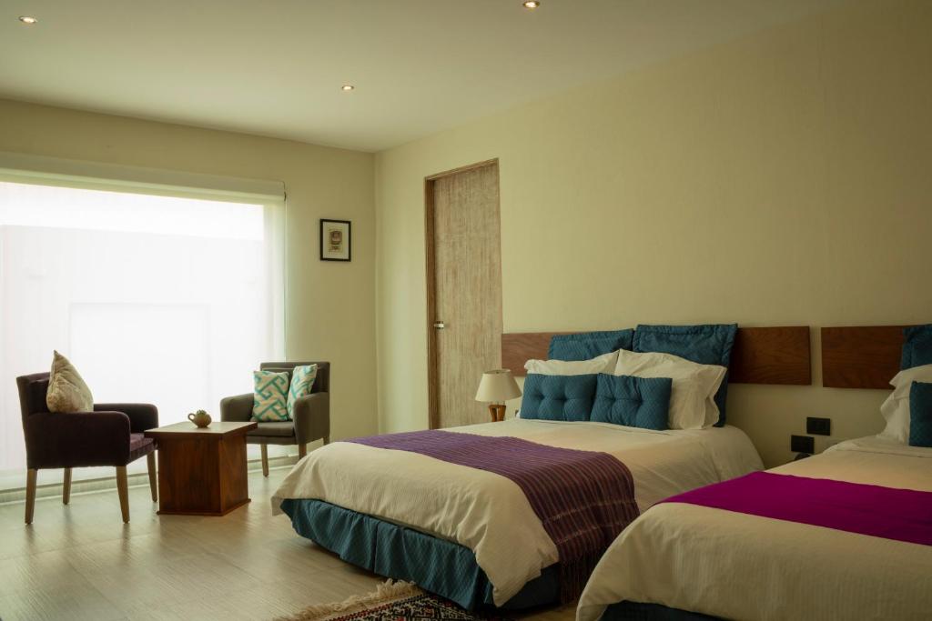 um quarto de hotel com duas camas e uma janela em Hotel Nak'An Secreto Maya em Comitán de Domínguez