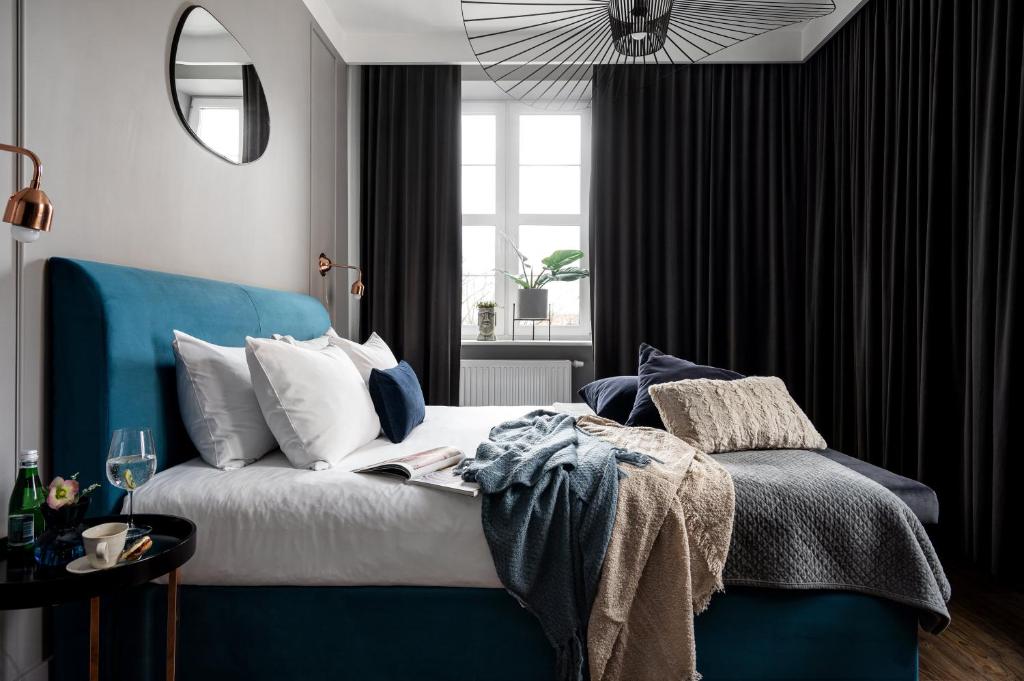 a bedroom with a blue bed and a window at TS Boutique Apartments in Szczecin