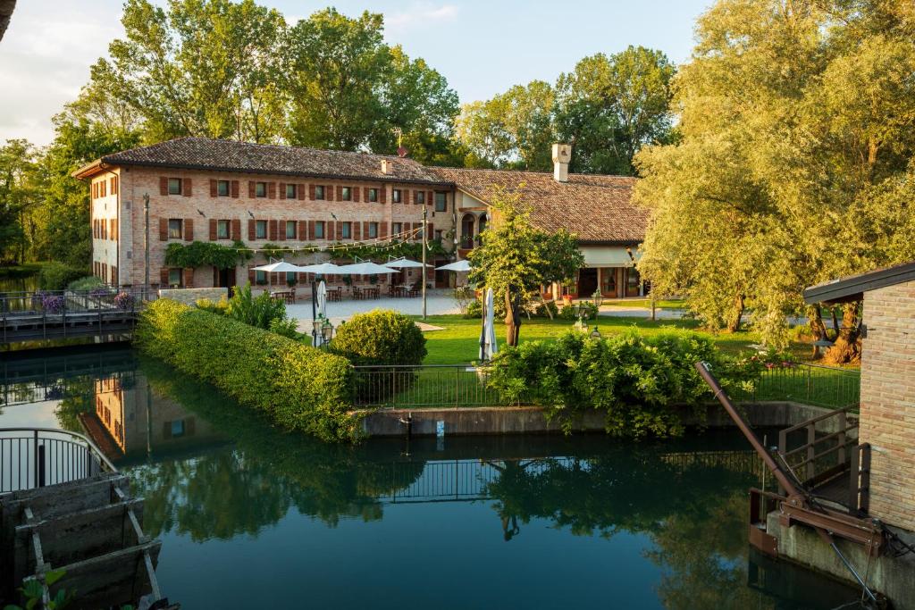 une rivière en face d'un bâtiment à côté d'un bâtiment dans l'établissement Ca' Muliner, à Azzano Decimo