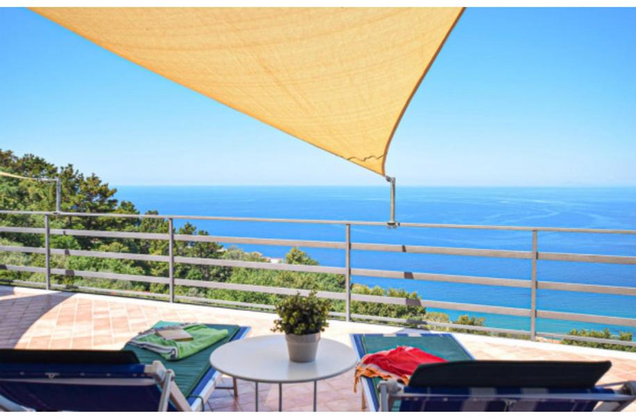 balkon ze stołem i krzesłami oraz oceanem w obiekcie la pennichella w mieście Castellabate