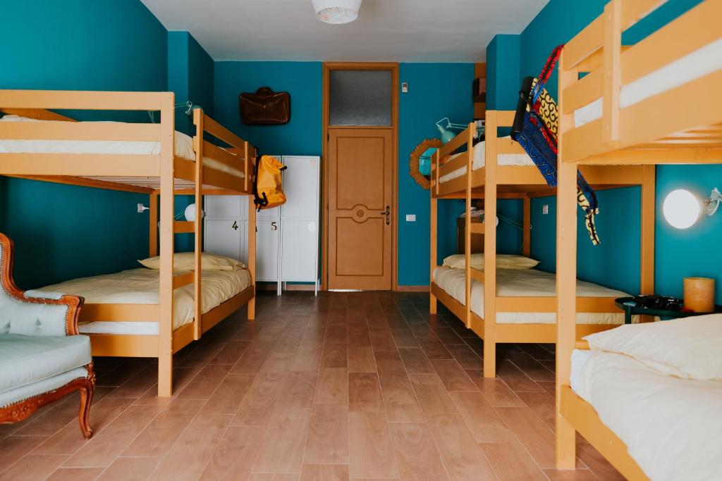 Habitación con 4 literas y paredes azules. en Habari We Dorm en Bari