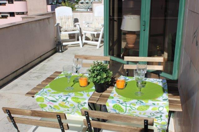 a patio with two chairs and a table with glasses at Espaçoso apartamento junto ao metro in Lisbon