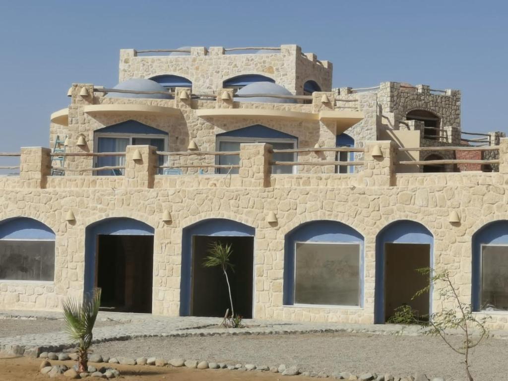 un edificio en el desierto con una palmera delante en Light House, en Marsa Alam