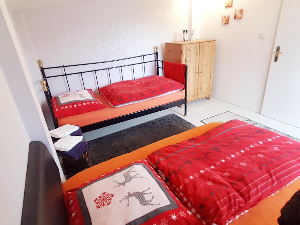 希察克的住宿－Ferienhaus Kunterbunt II，一间卧室配有两张红色床单