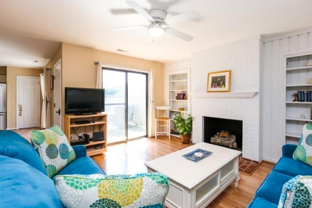 a living room with a blue couch and a fireplace at The Wright Place in Kitty Hawk