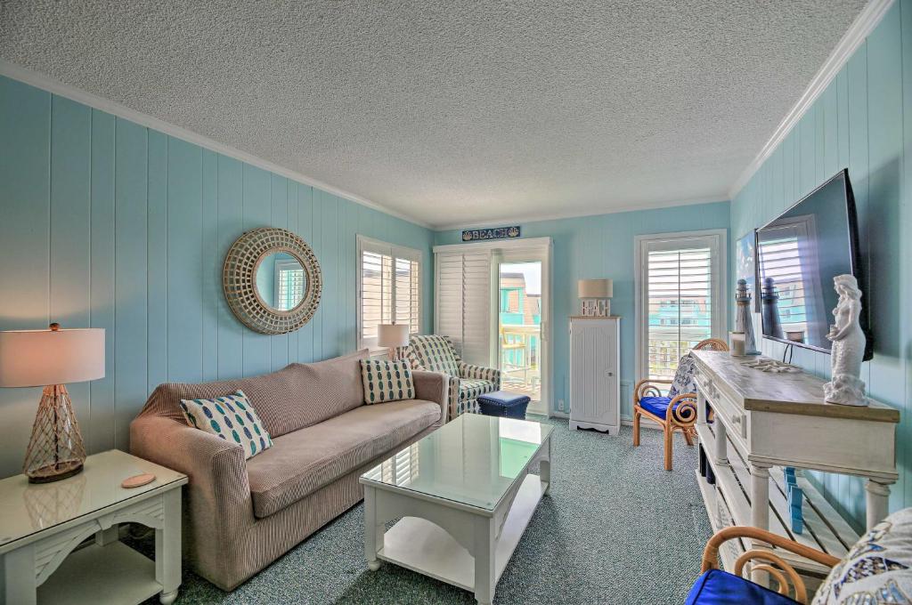 uma sala de estar com um sofá e uma mesa em Beachfront Condo with Boardwalk and Pool Access! em Atlantic Beach