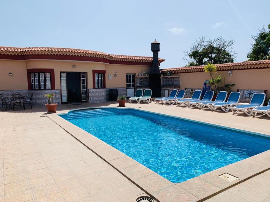 - une piscine avec des chaises et une maison dans l'établissement Vivienda Vacacional FLORATERE, à Arona