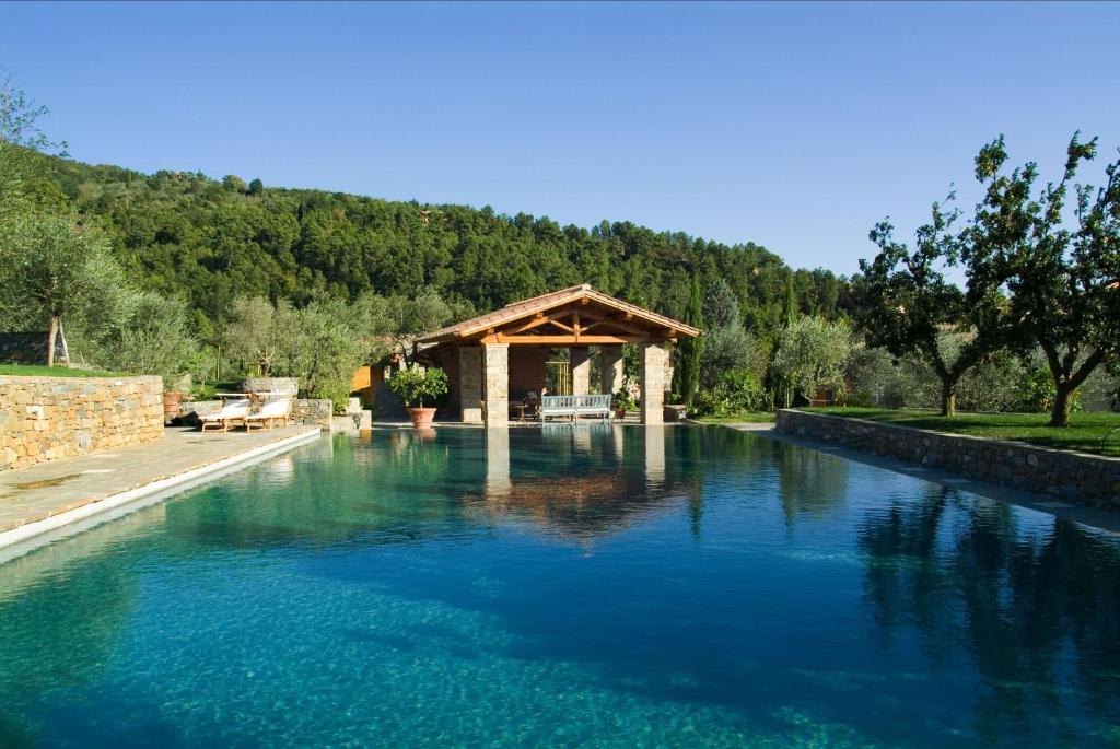 una piscina de agua azul con cenador en Fattoria Casamora - Suites, en Pian di Scò