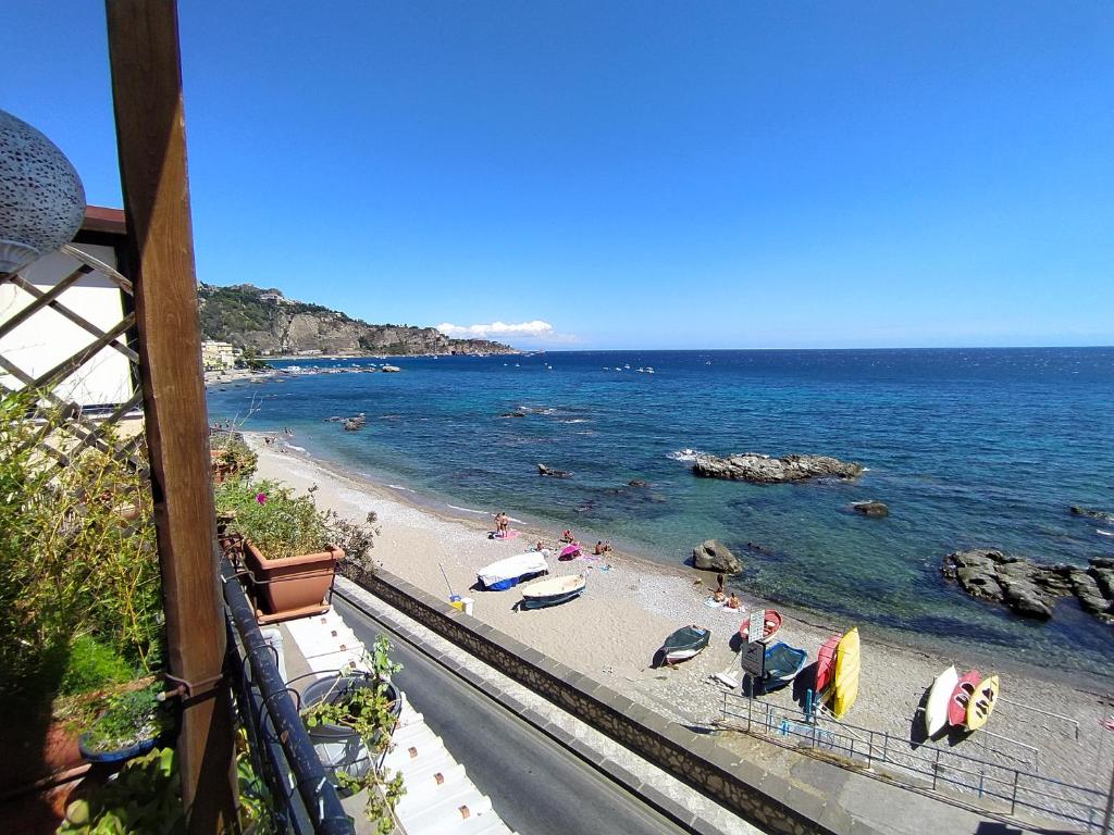 a beach with umbrellas and people on the sand at Appartamento Teocle beach in Giardini Naxos