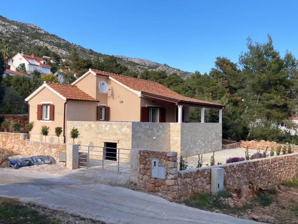 a house in the mountains with a stone wall at Tara house in Zavala