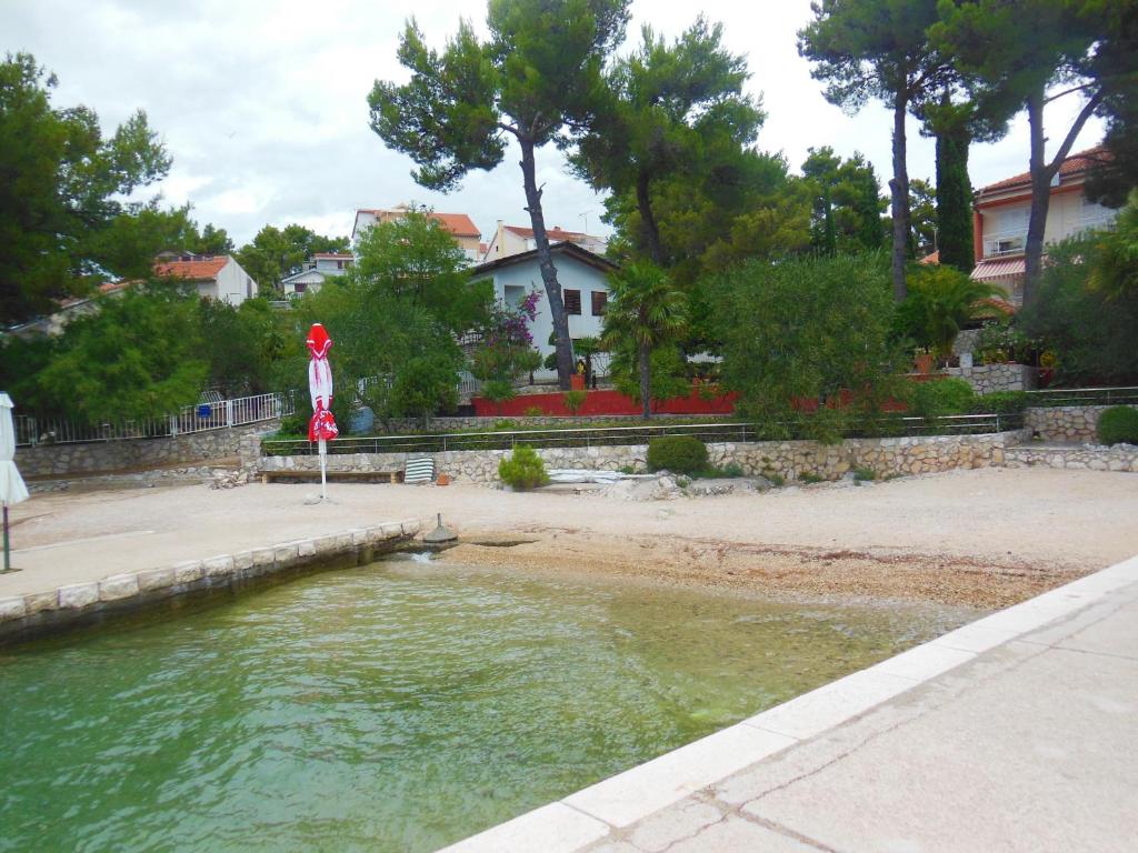 a body of water with a house in the background at Holiday Home Oleander in Zaboric