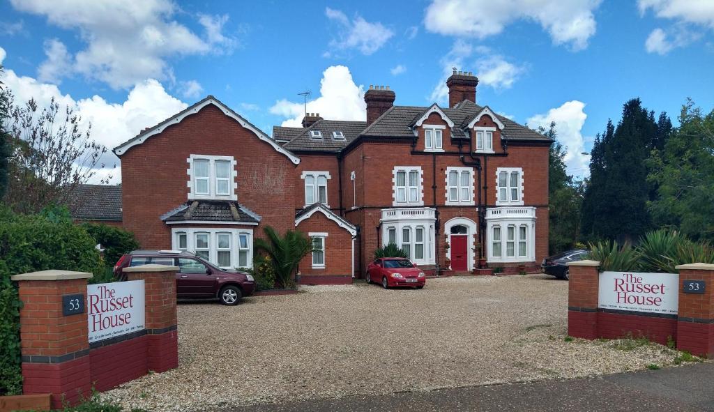 a large brick house with cars parked in front of it at The Russet House in Kings Lynn